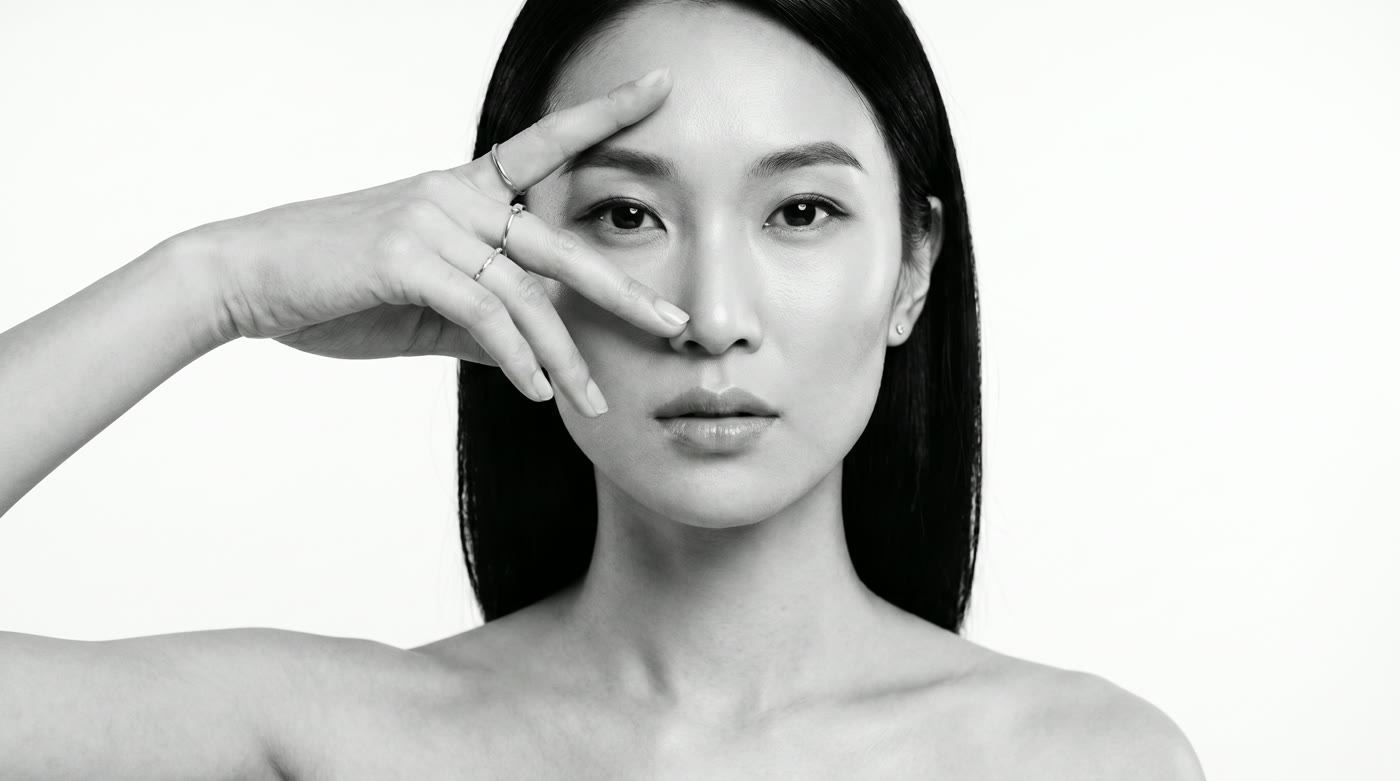 Black-and-white beauty portrait, a hand framing the face