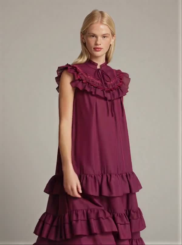 A model presents a berry dress with a ruffled neckline